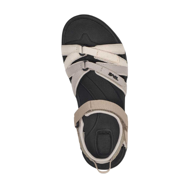 Top view of the TEVA Women's Tirra Black/Birch Multi sandal featuring a black footbed, beige crisscross straps, Velcro ankle closure, visible TEVA branding, and a rounded sole for comfort and reliable arch support.