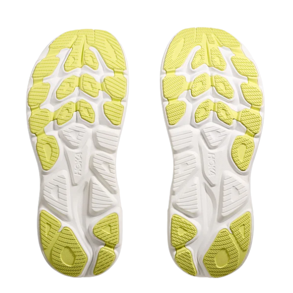 Two HOKA Women's Clifton 10 Carnation athletic shoe soles, with white bases and yellow textured grip patterns, shown side by side on a white background—lightweight cushioned running shoes ideal for plantar fasciitis.