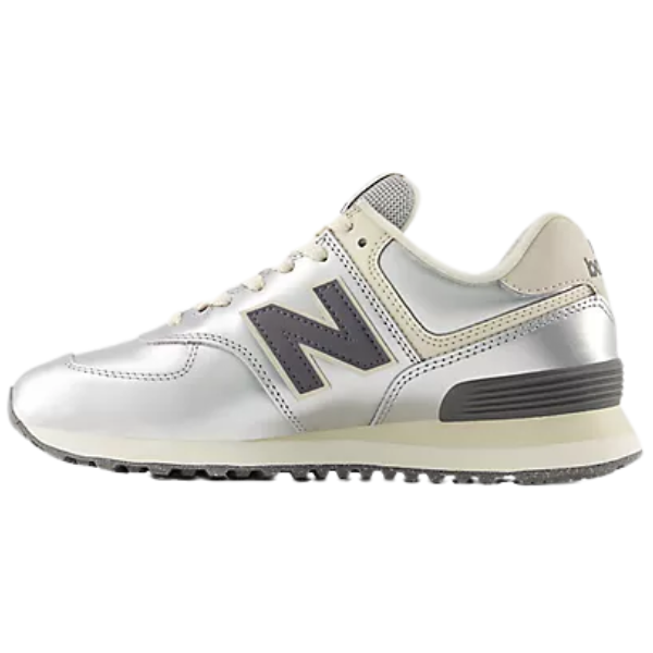 The New Balance Women's 574 in Metallic Silver/Arctic Grey features a black N logo and textured sole for comfort.