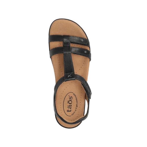 Top view of Taos Women's Trophy 2 Black Emboss sandal featuring tan footbed and cushioned arch support for comfort.