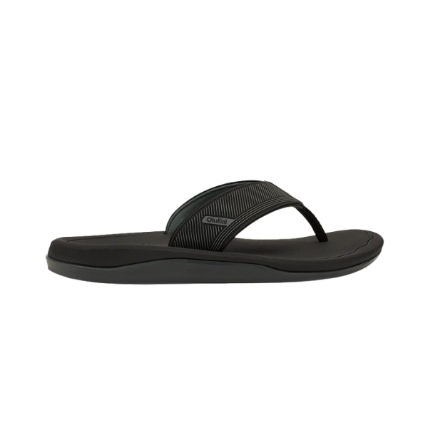 The OLUKAI Men's Ahi Kai Black/Black flip-flop offers wet grip and cushioning, ideal for ocean adventures.