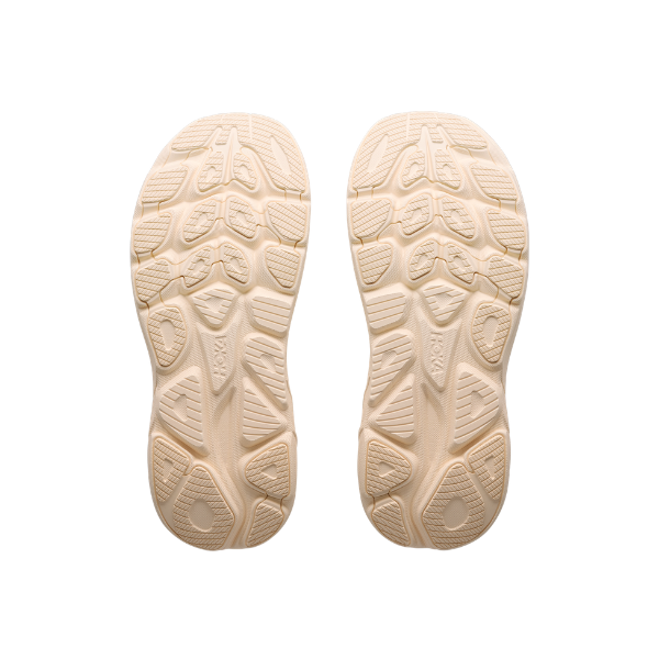 Beige rubber soles with patterned tread—ideal for HOKA Women's Clifton 11 Albaster/Oat Milk cushioned running shoes.