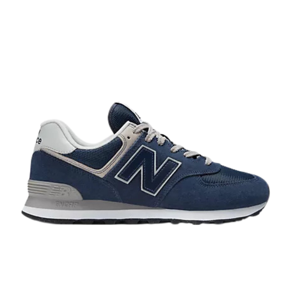 The New Balance Mens 574 Navy sneaker features white and grey accents, the signature N logo, white laces, a white midsole, and a black outsole from NEW BALANCE, displayed against a plain white background.