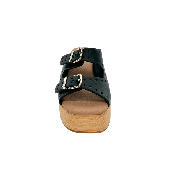 A single Sovella Womens Paola Black sandal by SOVELLA with two perforated straps, silver buckles, a light brown wooden sole, and supportive heels is shown from the front against a white background.