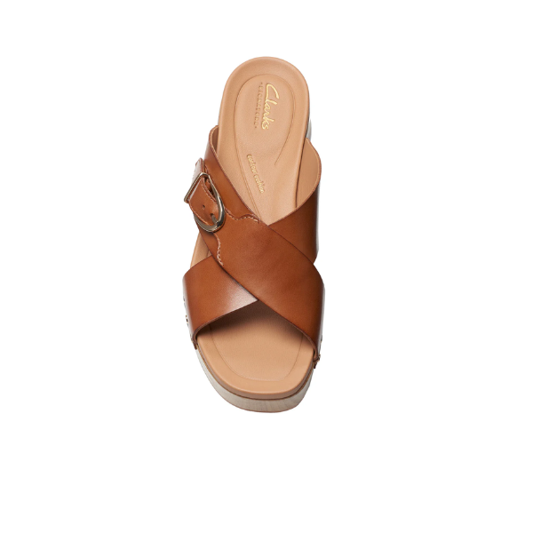 A single CLARKS Womens Sivanne Walk Tan sandal with crisscross straps, a large buckle, and Cushion Soft footbed is shown from above against a white background.