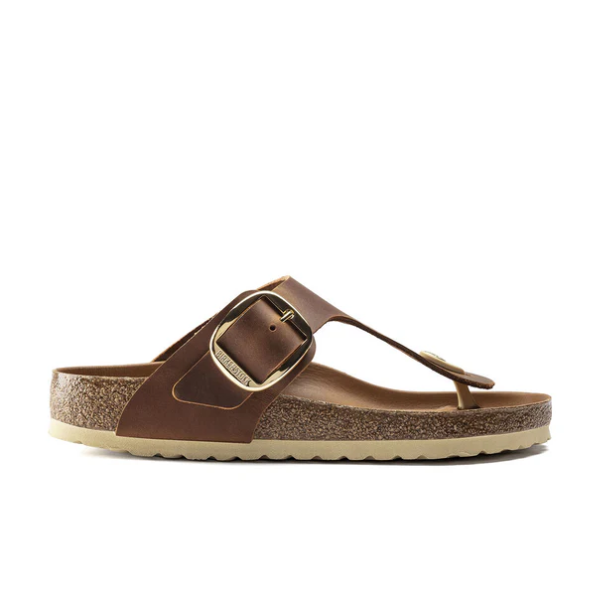 The BIRKENSTOCK Womens Gizeh Big Buckle Oiled Leather Cognac sandal is shown in side profile, highlighting its cork footbed and beige rubber sole, set against a white background.