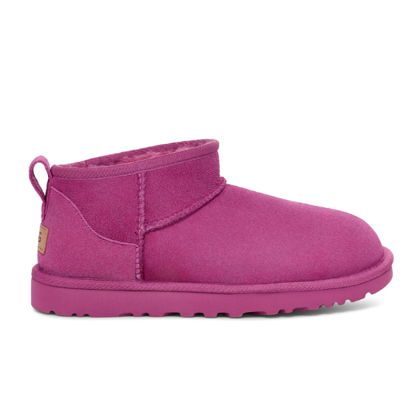 The UGG Womens Classic Ultra Mini Boot in purple suede features visible stitching, a flat sole, and a small back pull tab.