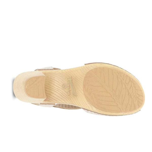 Dansko Womens Teagan White slingback sandal by DANSKO shown from the bottom, with a textured sole featuring a leaf pattern and embossed brand logo—crafted for style and foot pain relief.