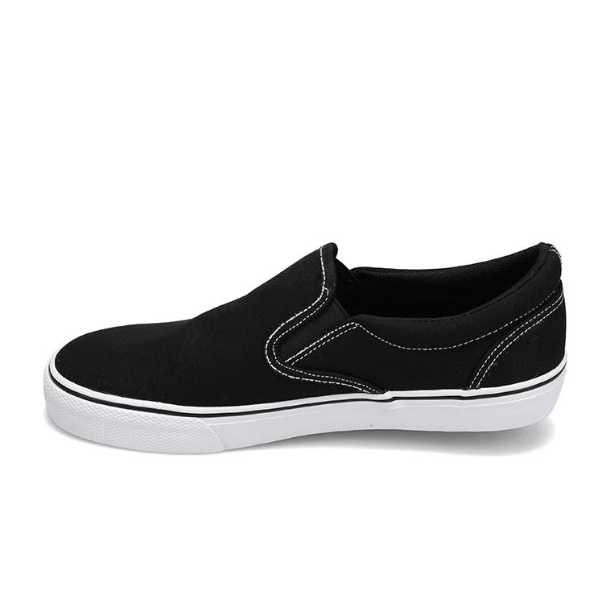 The Rival Womens Deuces Black/White by RIVAL, INC. is a black slip-on canvas sneaker with white stitching and a white rubber sole, shown in side profile on a plain white background.