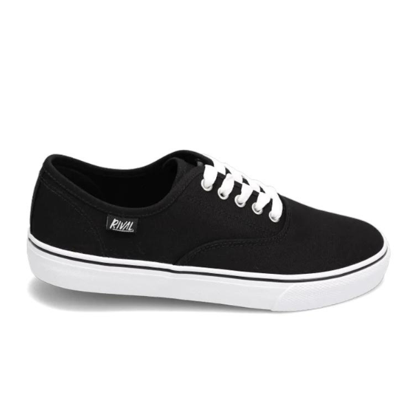 The Rival Womens Trips Black/White by RIVAL, INC. is a black canvas sneaker with white laces and a white rubber sole, shown side-on. It features a Rival label near the laces and a cushioned Rival+ footbed for all-day comfort.