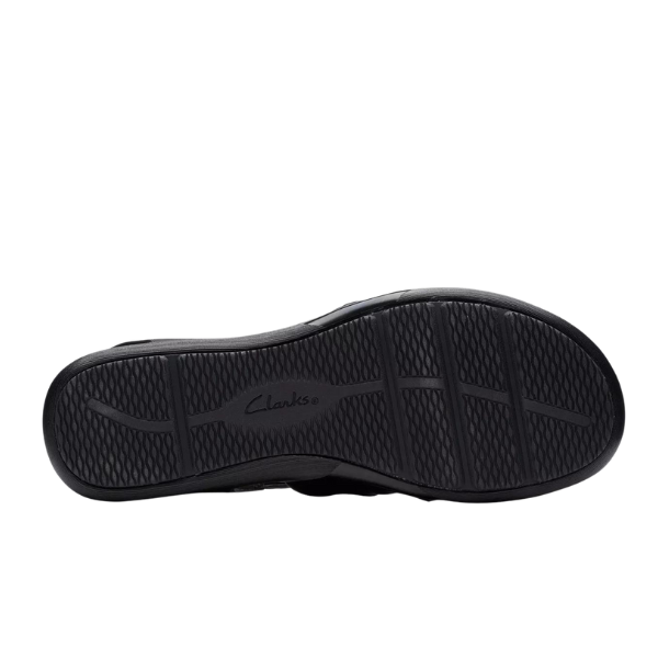 The image displays the black rubber sole of the CLARKS Womens Wide Kitly Ave Black Leather sandal, with a textured pattern of horizontal and wavy grooves for traction and the Clarks logo embossed in the center.