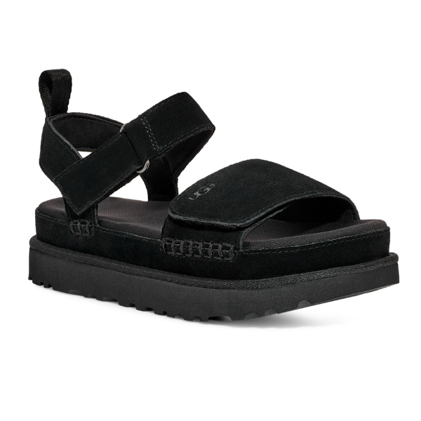 The UGG Womens Goldenstar Sandal Black features black suede, an open toe, Wide front strap, adjustable hook-and-loop ankle strap, SugarSole EVA sole for comfort, and a textured tread. The sandal is displayed on a white background.