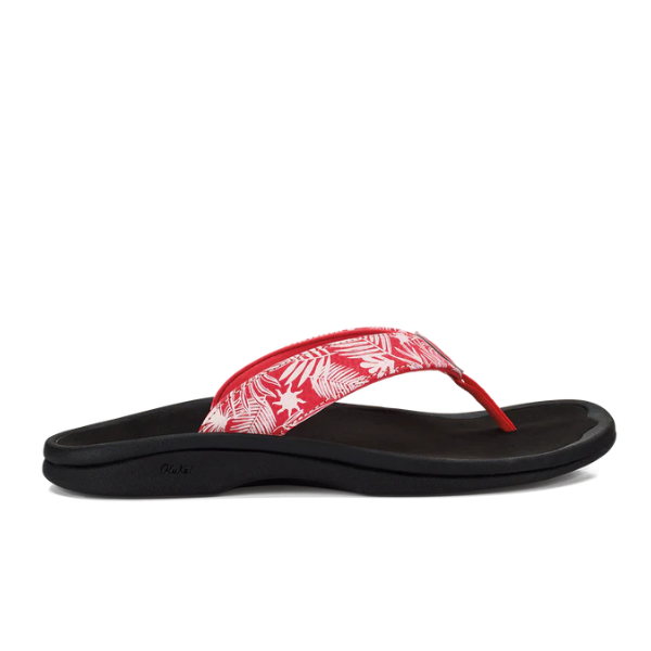 The OLUKAI Womens Ohana in Coral, Lehua Flower, and Onyx features a tropical leaf-patterned strap and black cushioned anatomical footbed, shown in side profile.