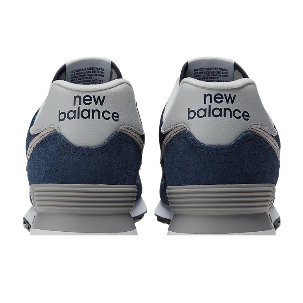 The New Balance Mens 574 Navy running shoes, shown from the back with visible NEW BALANCE branding on the white heel tabs, offer comfort and support designed to help reduce foot pain.