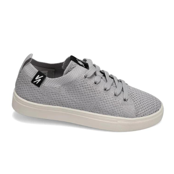 The Rival Womens Ace Knit Light Grey by RIVAL, INC. is a light gray knit sneaker with gray laces, a white rubber sole, and a black logo tag near the ankle. It offers breathability and features an abrasion-resistant outsole for durability.