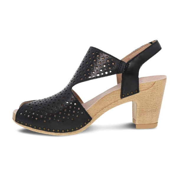 The Dansko Womens Teagan Black slingback sandal by DANSKO features a perforated design, open toe, decorative studs, and a tan wooden block heel—combining stylish comfort with support for pain-free wear.