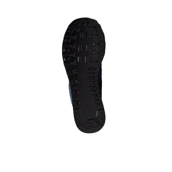 The image displays the black rubber sole of the NEW BALANCE Mens 574 Navy running shoe, featuring a rugged tread for traction—viewed from below on a white background and designed to help reduce foot pain during daily wear.