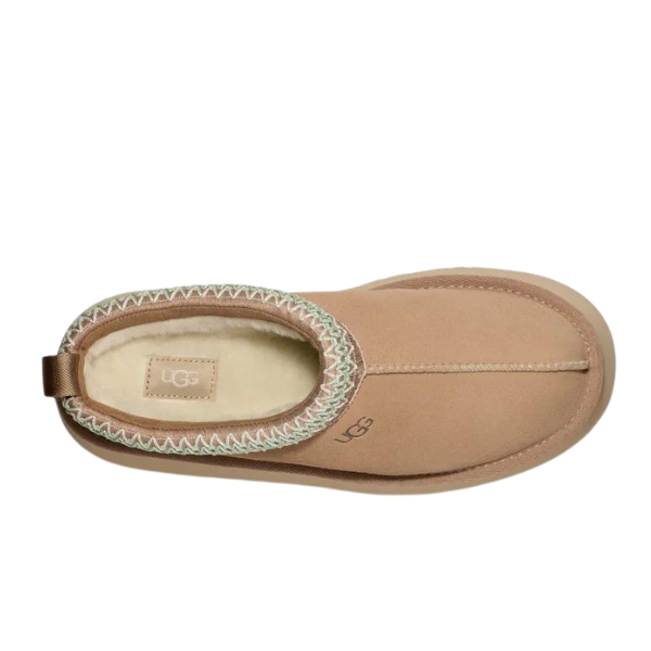 Top view of UGG Womens Tazz Slippers Sand shows visible stitching, cozy UGGplush lining, back pull tab, platform outsole, and UGG logos on insole and side for a stylish finish.