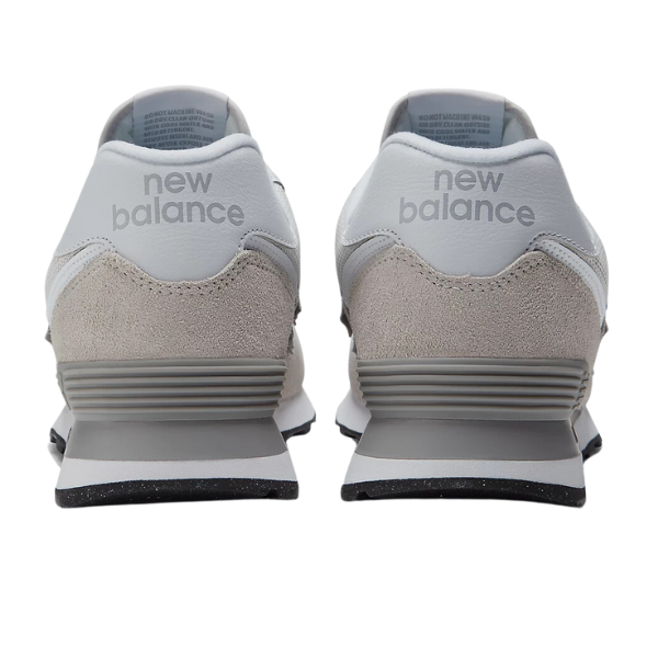 The New Balance Mens 574 White/Grey features gray suede and white leather accents with new balance on the heel tabs, designed by NEW BALANCE for comfort and foot pain relief.