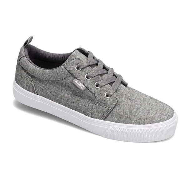 The Rival Womens Tilt Grey Chambray by RIVAL, INC. is a grey casual canvas sneaker with a white sole, abrasion-resistant rubber outsole, grey laces, and a small branded tag on the side, displayed against a white background.