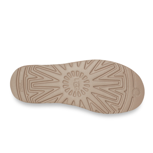 Beige shoe sole with a textured, geometric tread and central UGG logo, shown on white—an ideal match for the UGG Womens Classic Ultra Mini Sand boots.