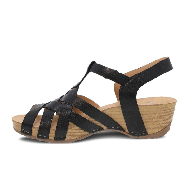 The DANSKO Womens Tinley Sandal Black features strappy black uppers, a tan textured wedge sole, open toe design, cushioned footbed for comfort, supportive back strap, and signature Natural Arch technology.