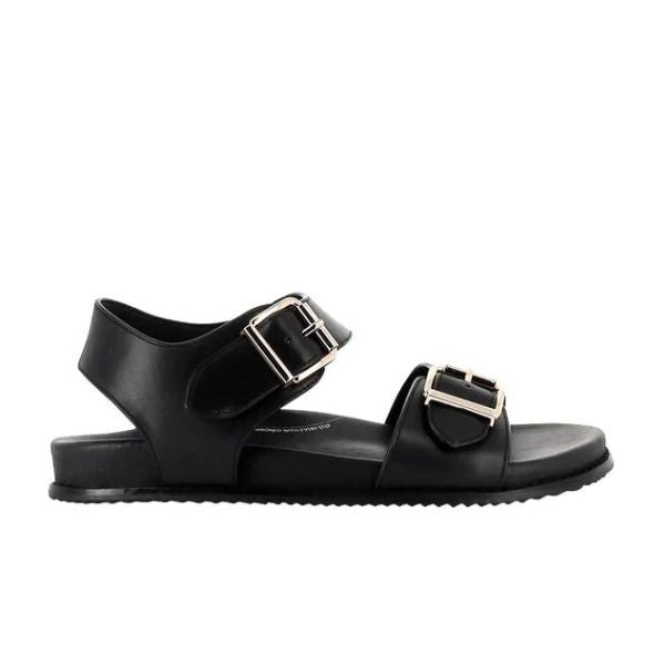 The ZIERA Womens Hastice Black Leather sandal features a flat sole, foam cushioning, and two Wide straps with silver buckles—one over the toes and one at the ankle. Simple and modern, its shown in a side photo.