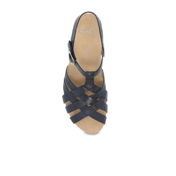 Top view of a single Dansko Womens Tinley Sandal in black woven leather with open toe, ankle strap, cushioned footbed, Natural Arch support, and tan insole by DANSKO on a white background.