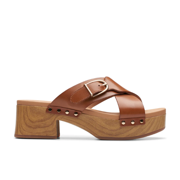 Side view of the Clarks Womens Sivanne Walk Tan sandals by CLARKS, with Wide crisscross leather straps, gold buckle, chunky faux wood platform heel with metallic studs, and Cushion Soft technology for all-day comfort.