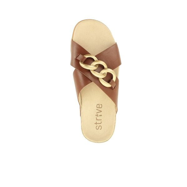 The Strive Womens Palma Link Tan sandal features crisscross leather straps, a bold gold chain detail, tan memory foam footbed for comfort, and strive printed on the insole. Brand: STRIVE.