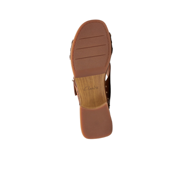 Bottom view of the Clarks Womens Sivanne Walk Tan sandal by CLARKS, showing a textured rubber sole, wood-patterned midsection, and Cushion Soft technology. CLARKS branding appears inside the heel area on a white background.