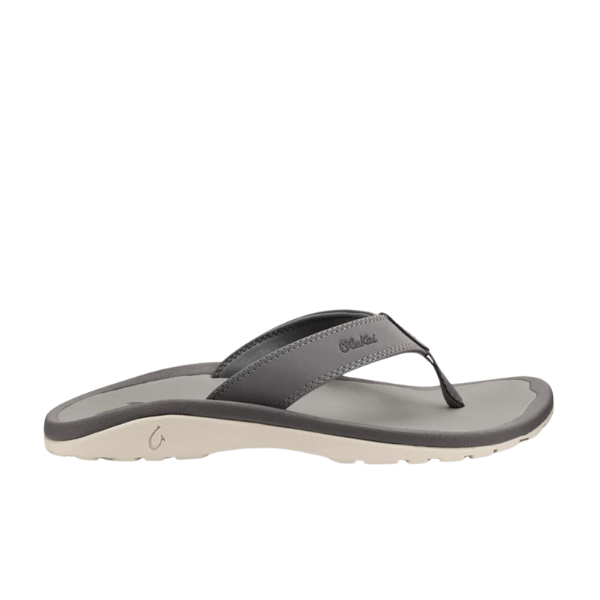 The OLUKAI Mens Ohana Graphite sandal features a gray thong-style strap, light beige sole, anatomical footbed, and textured footbed and outsole.