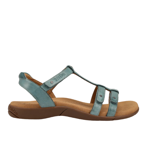 The TAOS Taos Womens Trophy 2 Teal is a teal blue leather sandal with an open toe, cushioned low tan sole, ankle strap, and two side straps for arch support and foot pain relief.