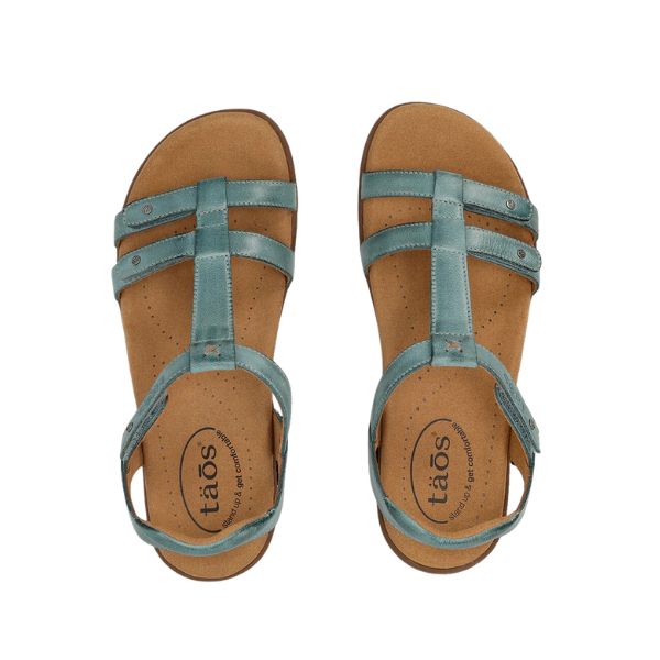 The Taos Womens Trophy 2 Teal leather strappy sandals feature tan cushioned insoles for arch support and foot pain relief, with adjustable ankle straps, open-toe design, and TAOS branding on the footbeds.