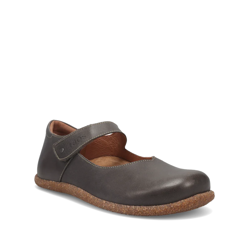 The TAOS Womens Ultimate Grey shoe, crafted from European leather with a brown cork sole and velcro strap, is displayed at an angle on a plain white background.