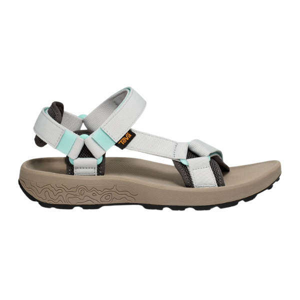 The Teva Womens Hydratrek Sandal White/Taupe features light gray, white, and mint green recycled polyester straps, a tan footbed, a textured black sole with traction tech, adjustable straps, and a small yellow side logo tag.