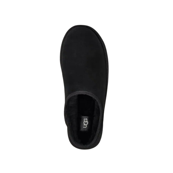 Top view of the UGG Mens Classic Slip-On Black slipper featuring a rounded toe, plush interior for comfort, and UGG logo on the insole, crafted from signature suede and sheepskin materials against a white background.