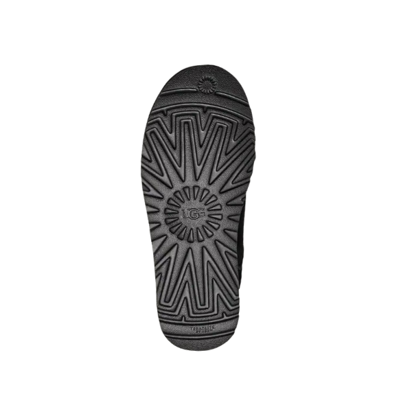 The UGG Mens Classic Slip-On Black features a bold geometric black sole with a sunburst tread and embossed UGG logo, designed for traction and foot comfort—ideal to pair with its suede and sheepskin upper.