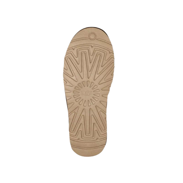 The UGG Mens Kenton Caribou features a beige sole with a sunburst center and zigzag grooves for traction, viewed from the bottom on a white background. Premium sheepskin lining offers comfort and warmth.