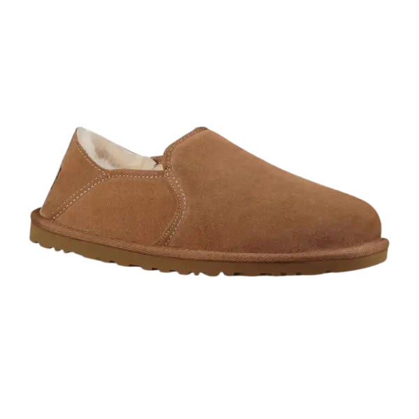 The UGG Mens Kenton Chestnut slip-on features brown suede, a tan rubber sole, white fleece lining, collapsible heel, and 17mm UGGplush™ for comfort. Shown from the side on a white background.