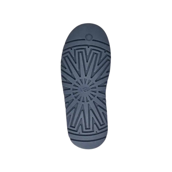 The UGG Womens Tazz Slippers Desert Blue feature a dark gray rubber sole with geometric and radial patterns plus circular details at the heel and center, offering grip, comfort, and foot pain relief.