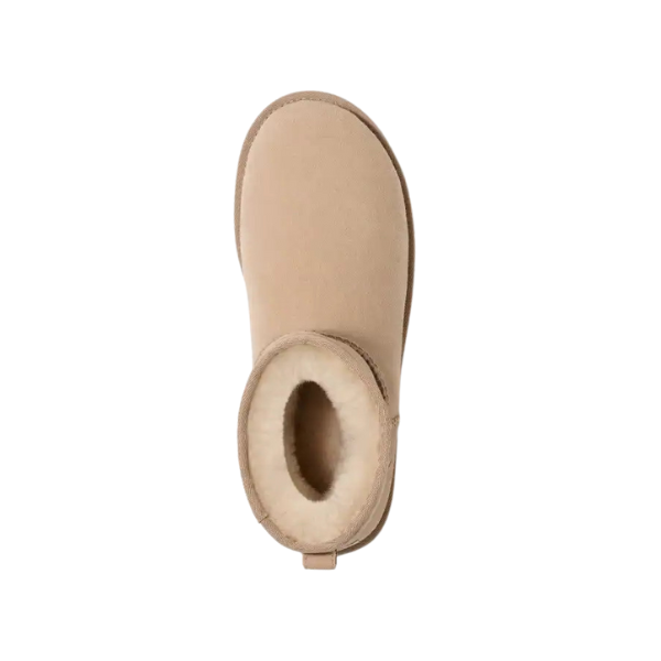 Top view of the UGG Womens Classic Mini II Boot in Sand—tan suede, rounded toe, and plush cream fur lining—offers cozy style and foot pain relief. Inspired by the iconic UGG Classic Boot. Isolated on white background.