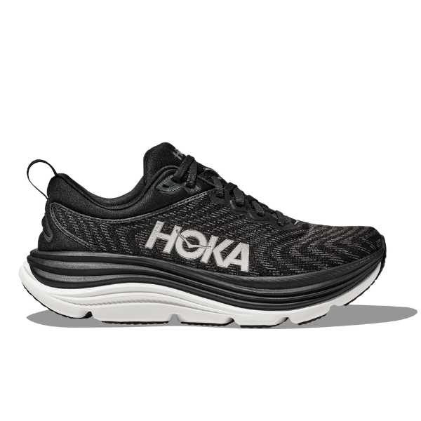 The HOKA Womens Gaviota 5 Wide Black/White is a running shoe with a cushioned sole, Stabilizing H-Frame tech, black laces, bold HOKA logo on the side, heel loop, and patterned mesh upper.