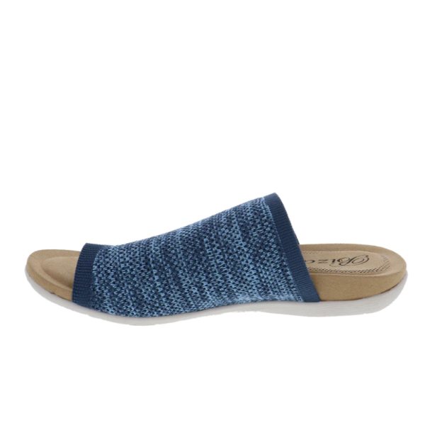 The BIZA FOOTWEAR Biza Womens Lavish Denim sandal features a blue stretch knit textured upper, open toe, and beige cushioned sole, displayed in side profile on a white background.