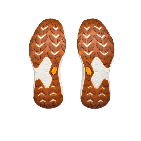 A pair of HOKA Womens Transport White shoes displayed from the bottom, showing brown zigzag rubber soles with white accents, designed for foot pain relief and isolated on a white background.