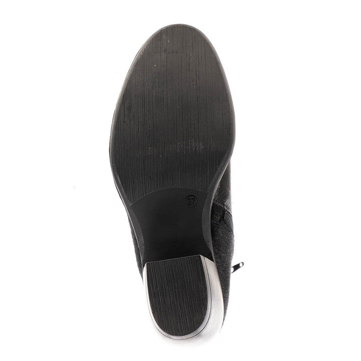 The bottom view of the Sovella Womens Misty Black boot by SOVELLA shows a black shoe with a smooth, lightly textured sole and a low heel to help relieve heel pain, displayed on a white background.