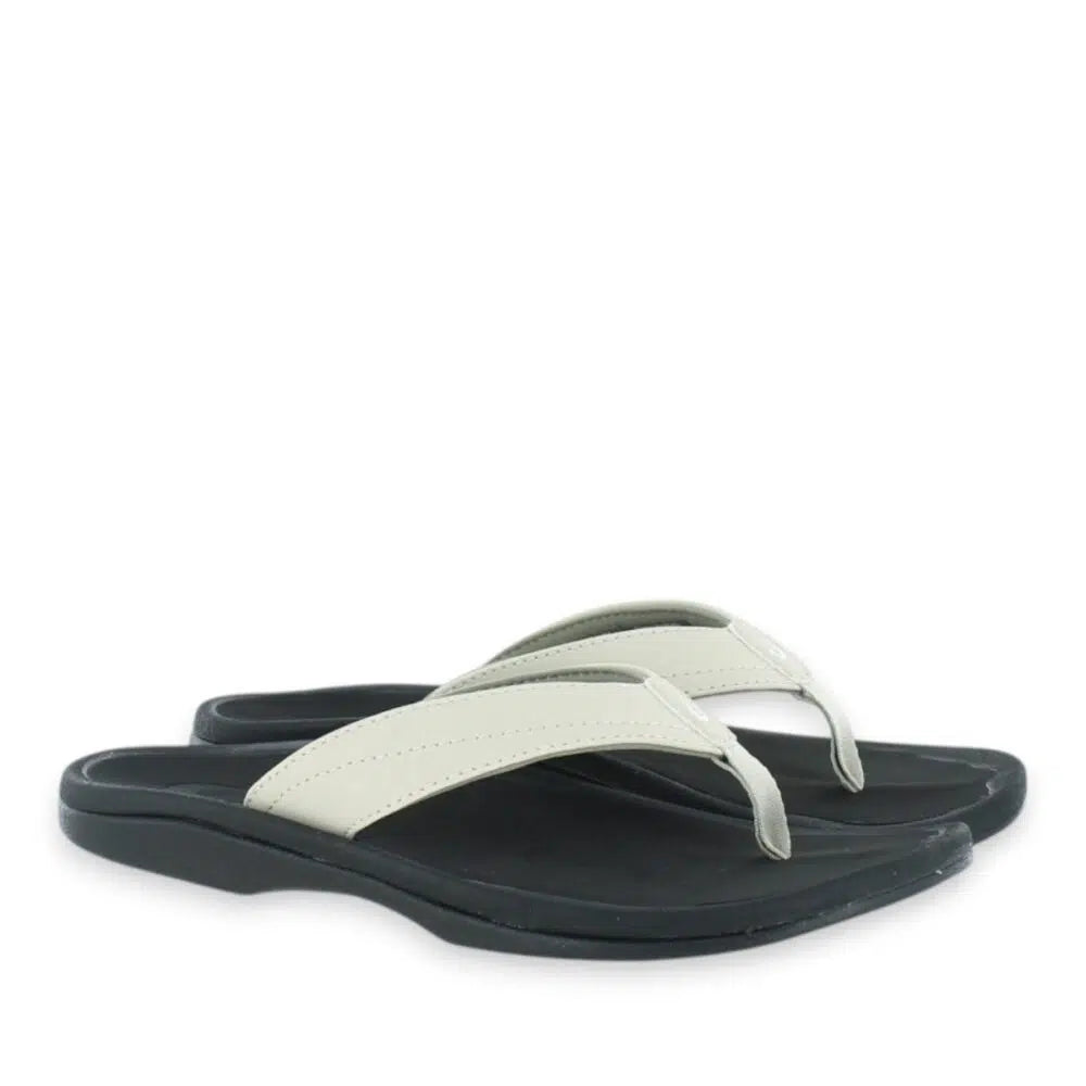 A pair of OLUKAI Women's Ohana Beige sandals, ecru straps and cushioned black footbeds with arch support, from above.