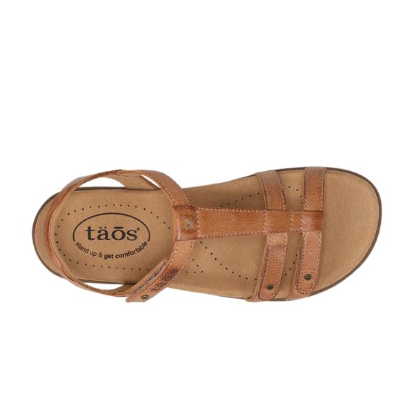 Top view of the Taos Womens Trophy 2 Honey sandal, featuring brown leather straps, a cushioned TAOS Soft Support™ footbed with arch and metatarsal support, and the TAOS logo printed on the heel.