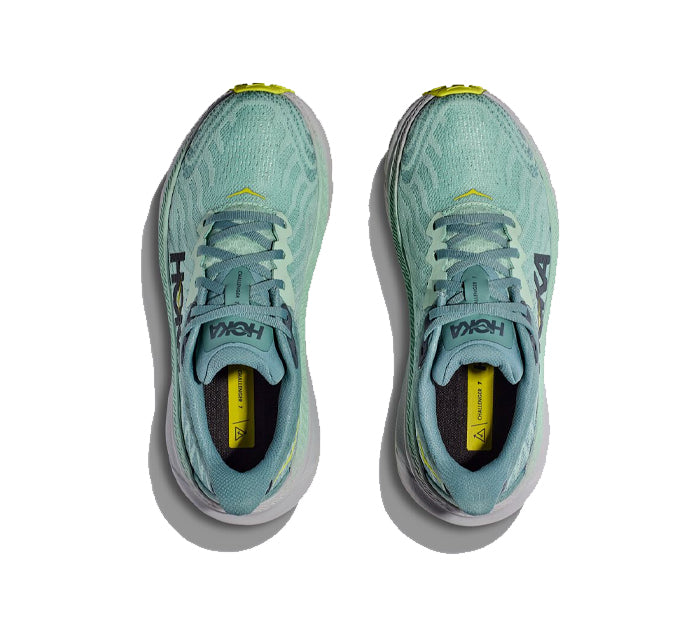 Top view of HOKA Womens Challenger ATR 7 Wide in Mist Green/Trellis with yellow accents and white soles, featuring the HOKA logo on the tongue and side. Shoes are displayed side by side on a white background.