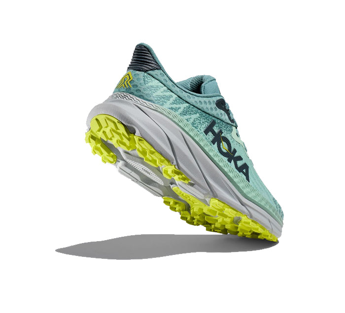 A HOKA Womens Challenger ATR 7 Wide in Mist Green/Trellis is shown from the rear, displaying its textured yellow-green sole, logo, and Wide fit against a white background with a shadow beneath.